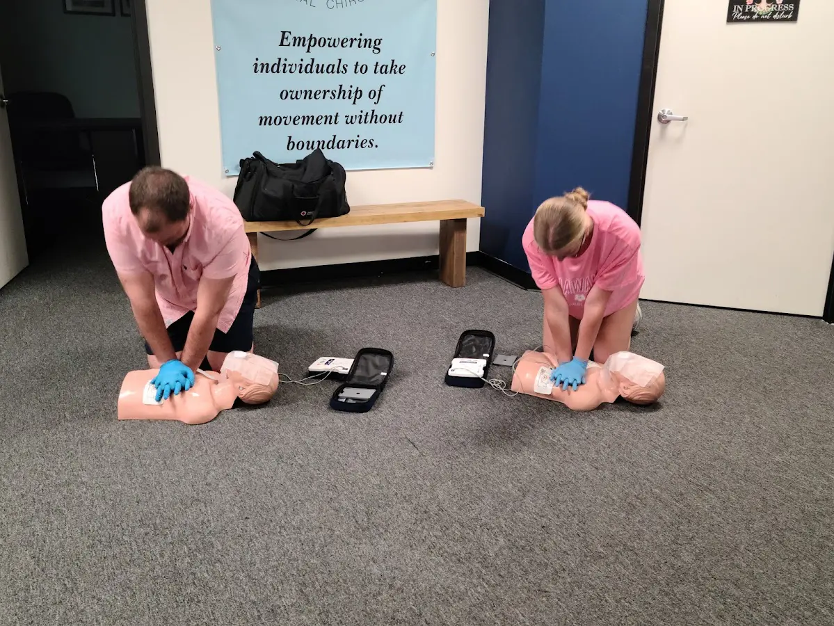 Two people are practicing cpr on dummies.